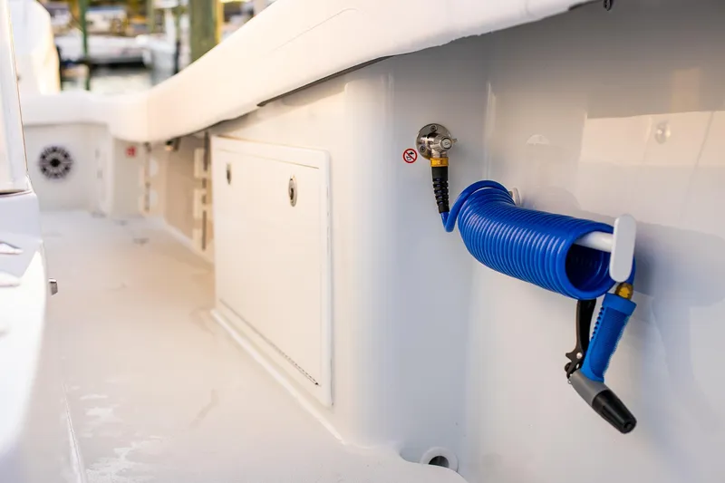 Slide: The Image of 2026 Yellowfin 36 Offshore boat deck with coiled blue hose and storage compartment. - 134