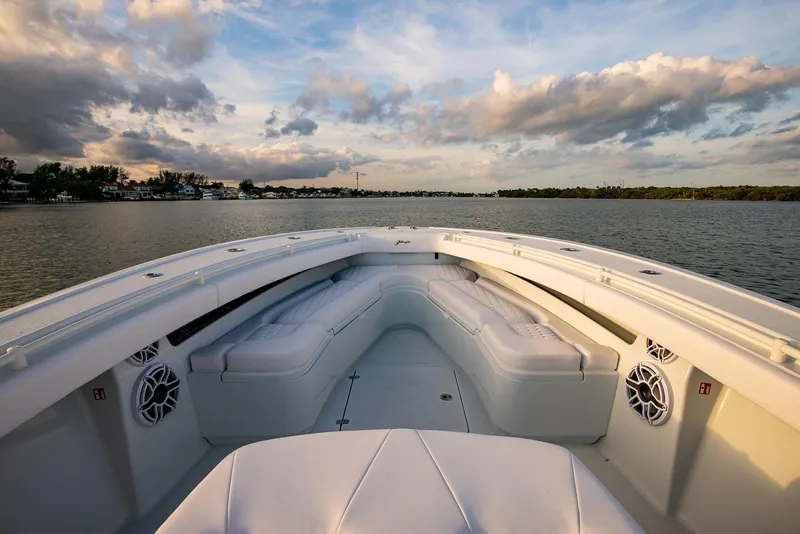 Slide: The Image of 2026 Yellowfin 36 Offshore boat interior with white seating, on calm water under a cloudy sky. - 153