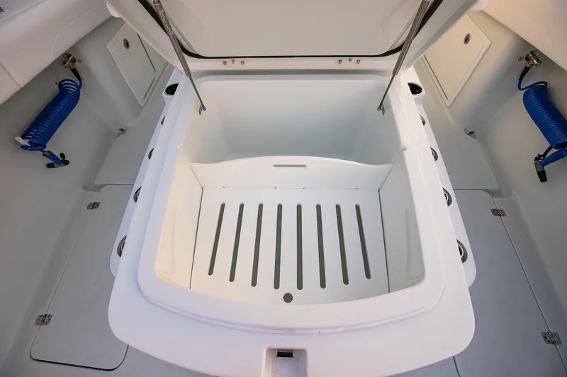 Slide: The Image of 2026 Yellowfin 36 Offshore boat storage compartment with open lid and blue hoses. - 162