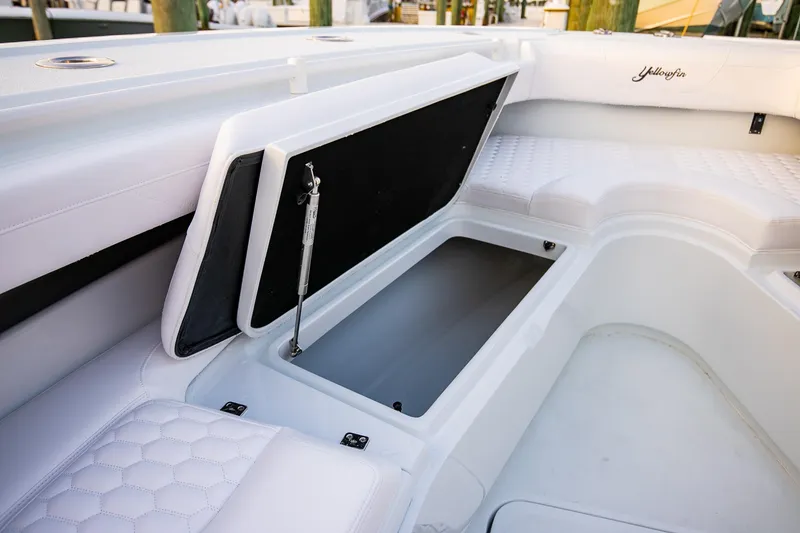 Slide: The Image of 2026 Yellowfin 36 Offshore boat interior with open storage compartment and cushioned seating. - 165