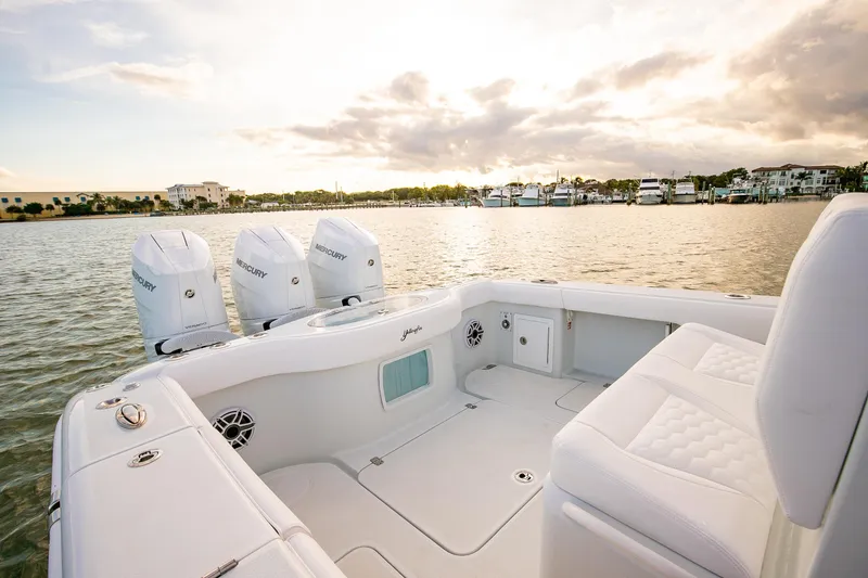 Slide: The Image of 2026 Yellowfin 36 Offshore boat with Mercury engines on a serene waterfront. - 22