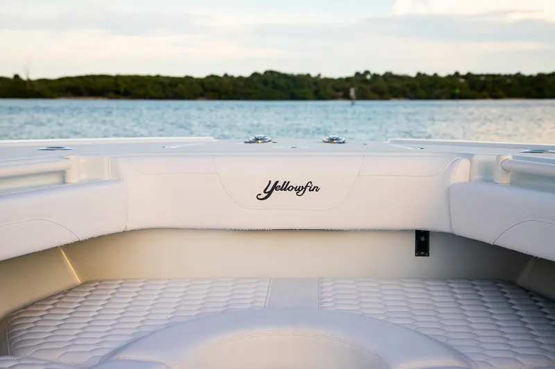 Slide: The Image of 2026 Yellowfin 36 Offshore boat interior with logo, overlooking serene water and lush greenery. - 28