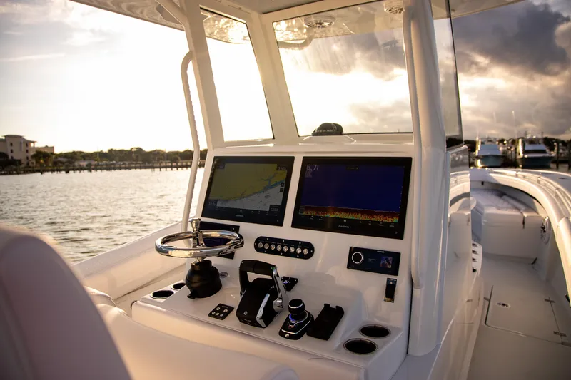 Slide: The Image of 2026 Yellowfin 36 Offshore boat cockpit with advanced navigation systems at sunset. - 36