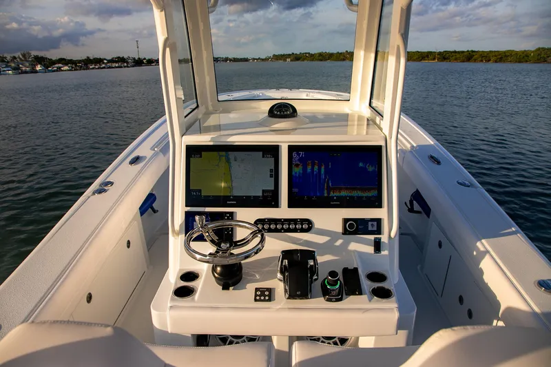Slide: The Image of 2026 Yellowfin 36 Offshore boat dashboard with navigation screens on calm water. - 47