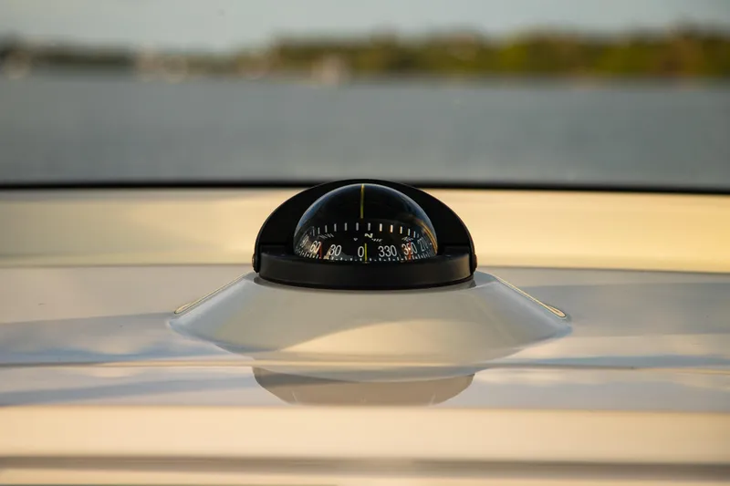 Slide: The Image of Compass on 2026 Yellowfin 36 Offshore boat, with blurred water background. - 51