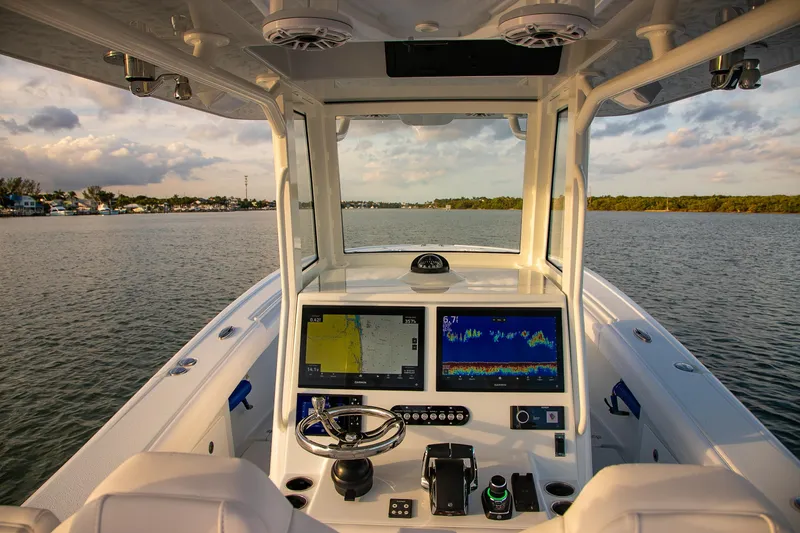 Slide: The Image of 2026 Yellowfin 36 Offshore boat dashboard with navigation screens on calm water. - 53