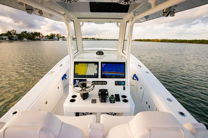 Slide: The Image of 2026 Yellowfin 36 Offshore boat cockpit with advanced navigation systems on calm water. - 55