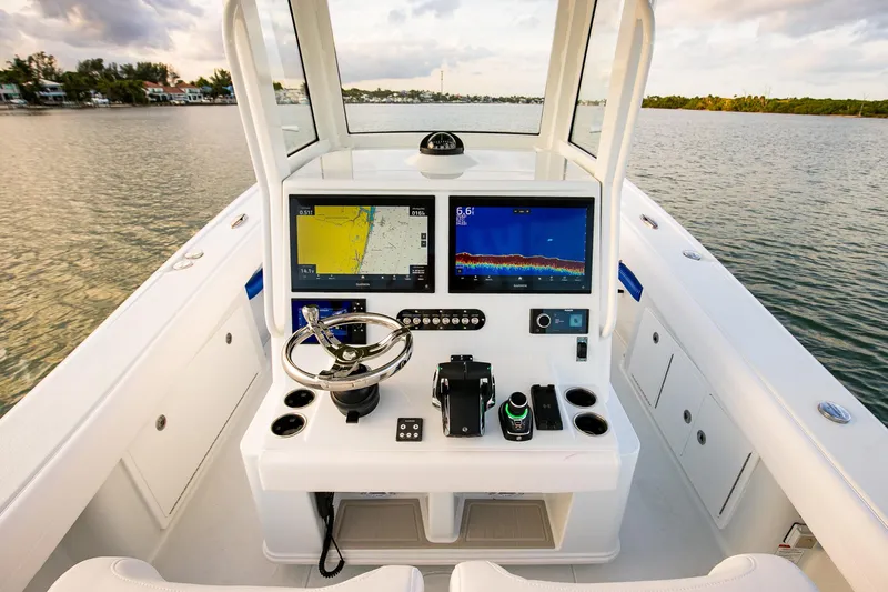 Slide: The Image of 2026 Yellowfin 36 Offshore boat cockpit with advanced navigation displays on calm water. - 56