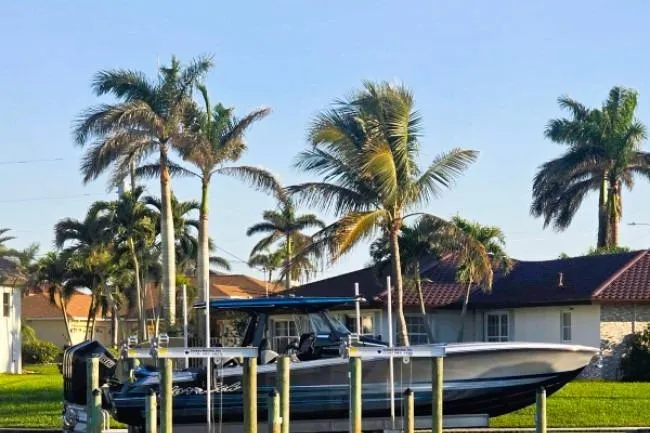 Slide: The Image of 2025 Nor-Tech 400 Supersport boat docked, surrounded by palm trees and houses. - 10