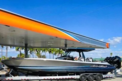 Slide: The Image of 2025 Nor-Tech 400 Supersport boat on trailer at gas station under clear blue sky. - 11
