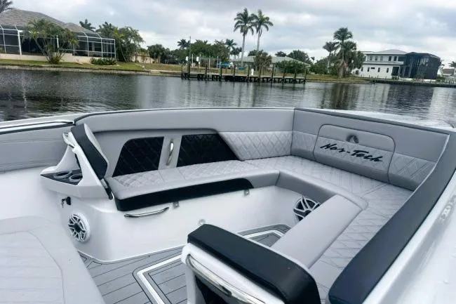 Slide: The Image of 2025 Nor-Tech 400 Supersport boat interior with luxurious seating by a scenic waterfront. - 3