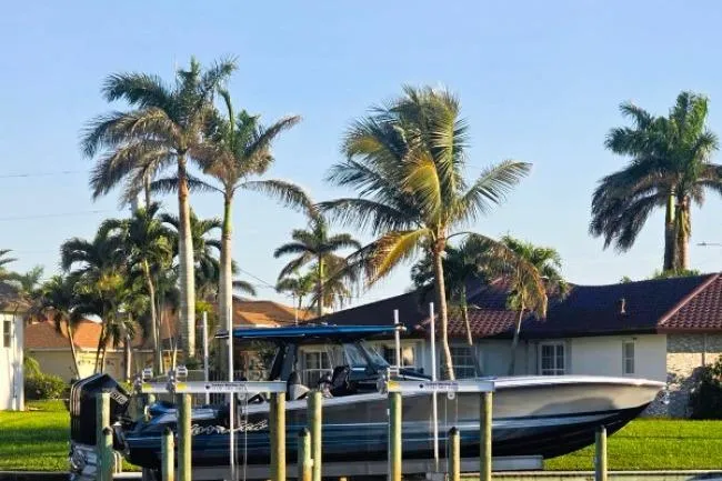 Slide: The Image of 2025 Nor-Tech 400 Supersport boat docked, surrounded by palm trees and waterfront homes. - 4
