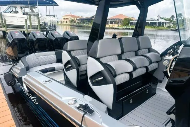 Slide: The Image of 2025 Nor-Tech 400 Supersport boat with luxurious seating and powerful engines docked by the water. - 9
