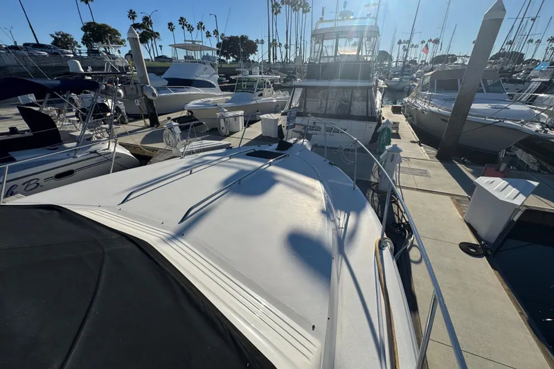 Slide: The Image of 1990 Sea Ray 380 Aft Cabin yacht docked at marina under clear blue sky. - 11