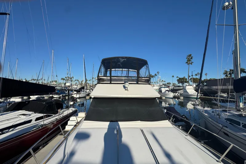 Slide: The Image of 1990 Sea Ray 380 Aft Cabin yacht docked in a marina under clear blue skies. - 12
