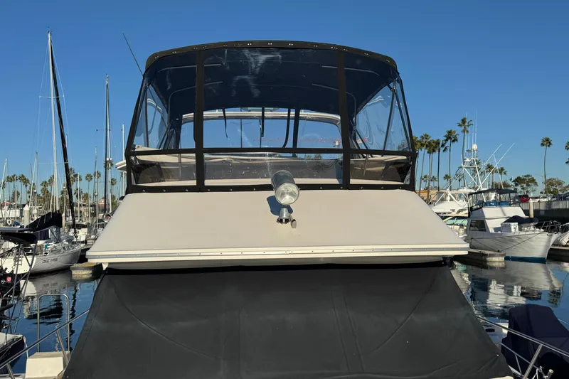 Slide: The Image of 1990 Sea Ray 380 Aft Cabin yacht docked in marina, clear blue sky. - 13