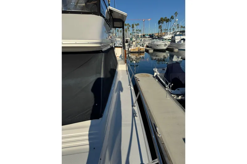 Slide: The Image of 1990 Sea Ray 380 Aft Cabin yacht docked in a marina, surrounded by other boats. - 14