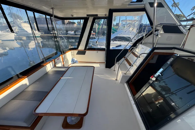 Slide: The Image of 1990 Sea Ray 380 Aft Cabin interior with seating and table, docked at marina. - 17