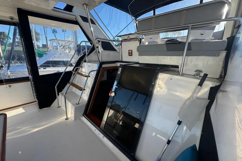 Slide: The Image of 1990 Sea Ray 380 Aft Cabin interior with seating and stairs, docked at marina. - 18