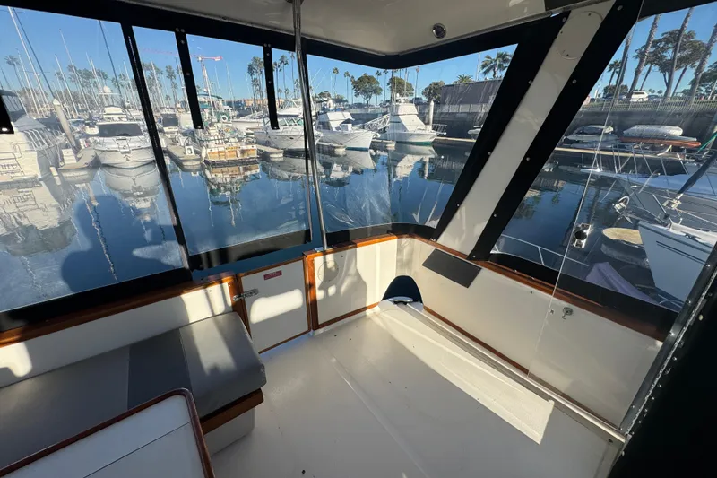 Slide: The Image of 1990 Sea Ray 380 Aft Cabin interior with marina view, featuring seating and windows. - 19