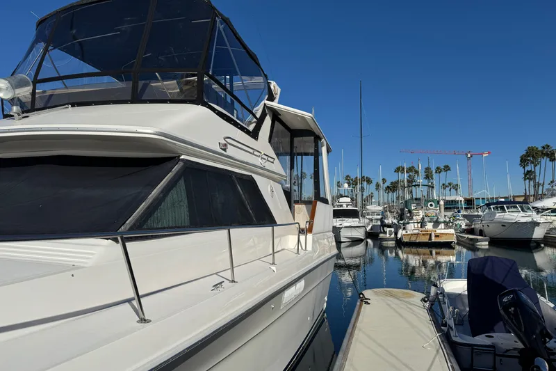 Slide: The Image of 1990 Sea Ray 380 Aft Cabin yacht docked in a marina under clear blue skies. - 2