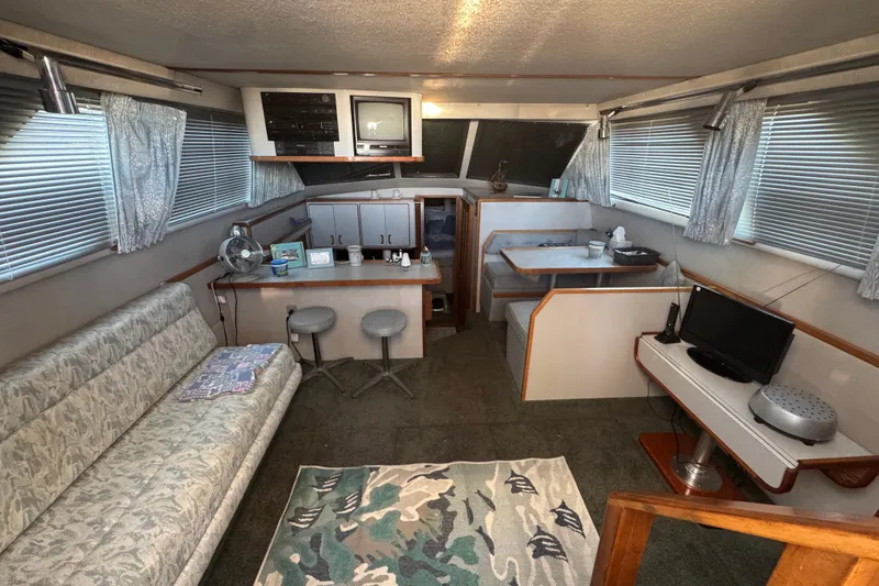 Slide: The Image of Interior of a 1990 Sea Ray 380 Aft Cabin with seating, TV, and dining area. - 21
