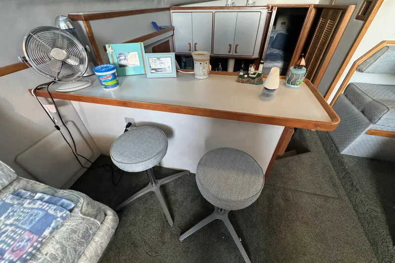 Slide: The Image of Interior of 1990 Sea Ray 380 Aft Cabin with bar stools and decor. - 26