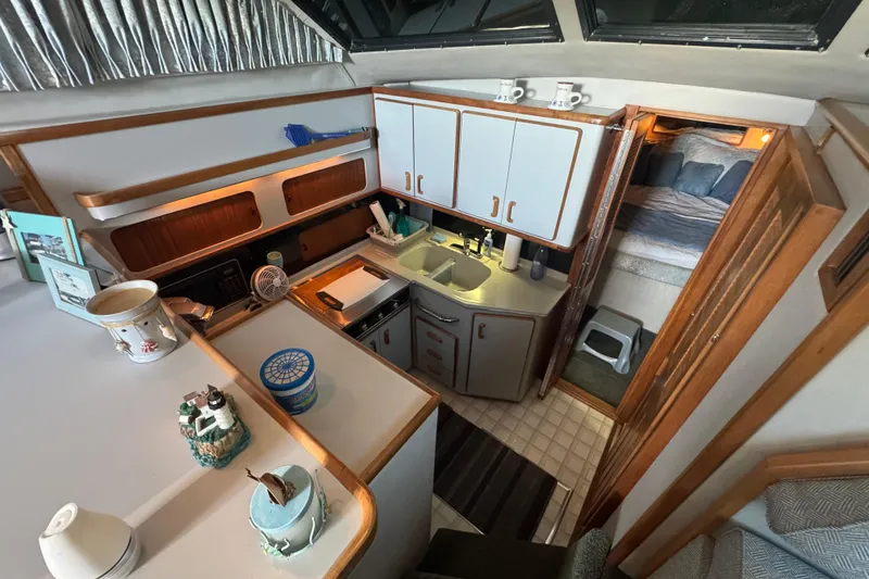 Slide: The Image of 1990 Sea Ray 380 Aft Cabin interior with kitchen and cozy sleeping area. - 28