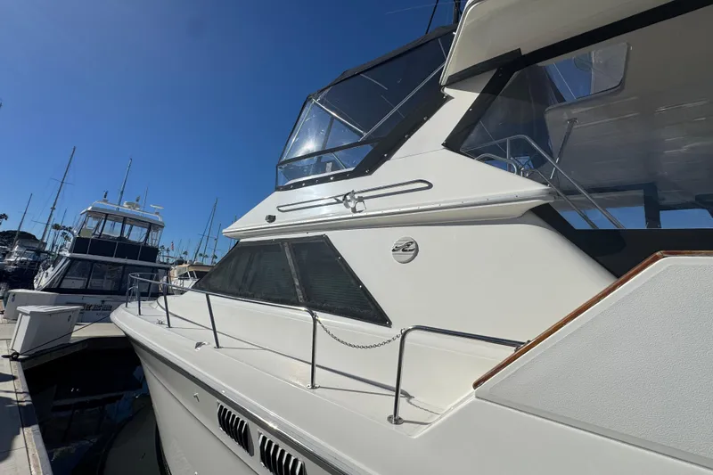 Slide: The Image of 1990 Sea Ray 380 Aft Cabin yacht docked at marina under clear blue sky. - 3