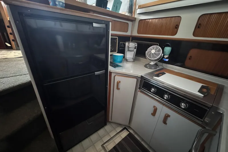 Slide: The Image of 1990 Sea Ray 380 Aft Cabin kitchen with fridge, stove, and appliances. - 30