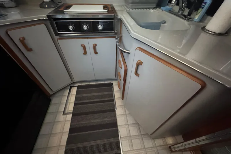 Slide: The Image of 1990 Sea Ray 380 Aft Cabin kitchen with stove, sink, and cabinets. - 34