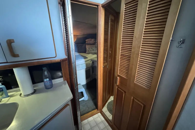 Slide: The Image of 1990 Sea Ray 380 Aft Cabin interior with wooden cabinets and cozy bedroom. - 35