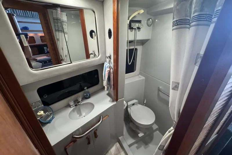 Slide: The Image of 1990 Sea Ray 380 Aft Cabin bathroom with sink, mirror, and shower. - 36