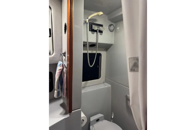 Slide: The Image of 1990 Sea Ray 380 Aft Cabin bathroom with shower, window, and towel rack. - 37