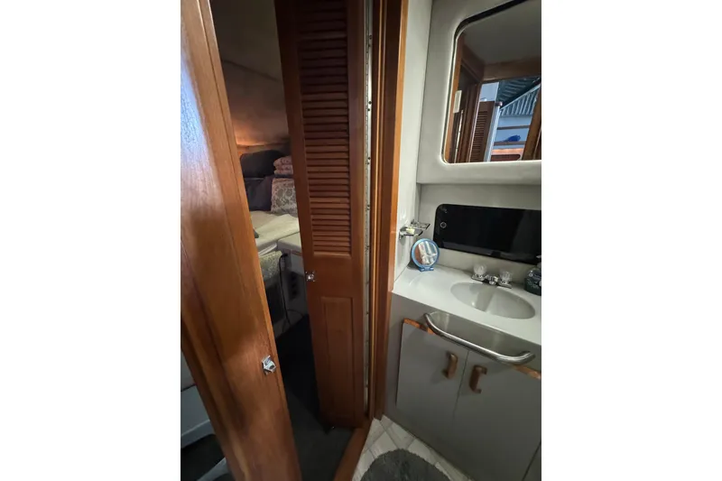 Slide: The Image of 1990 Sea Ray 380 Aft Cabin interior with bathroom and cozy bedroom view. - 38