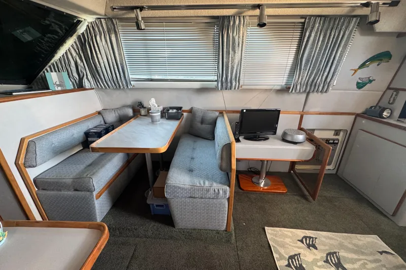 Slide: The Image of 1990 Sea Ray 380 Aft Cabin interior with dining area and small TV setup. - 42