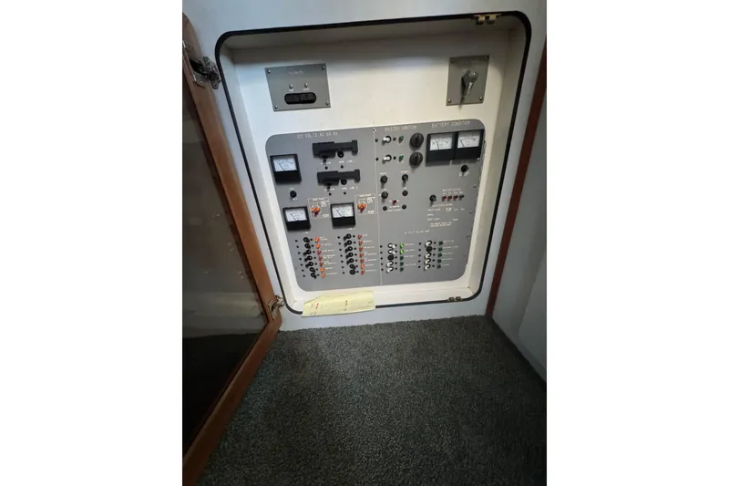 Slide: The Image of Electrical control panel inside 1990 Sea Ray 380 Aft Cabin boat, featuring gauges and switches. - 44