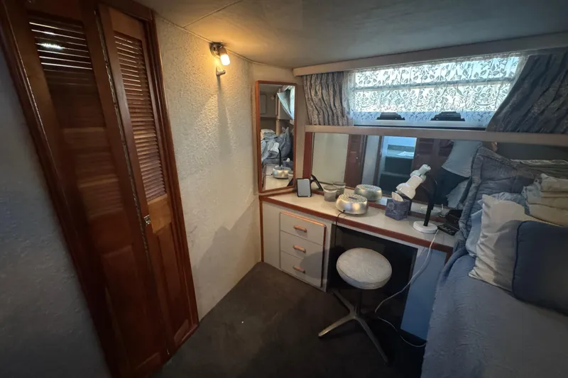 Slide: The Image of 1990 Sea Ray 380 Aft Cabin interior with vanity, mirror, and cozy decor. - 48