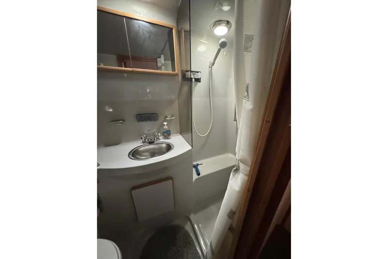 Slide: The Image of 1990 Sea Ray 380 Aft Cabin bathroom with shower, sink, and mirror. - 52