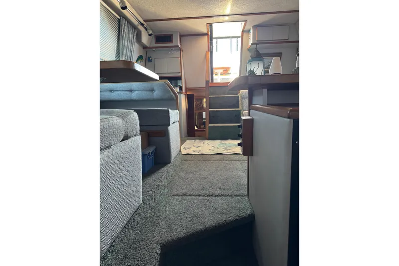 Slide: The Image of Interior of 1990 Sea Ray 380 Aft Cabin yacht, featuring cozy seating and carpeted flooring. - 54