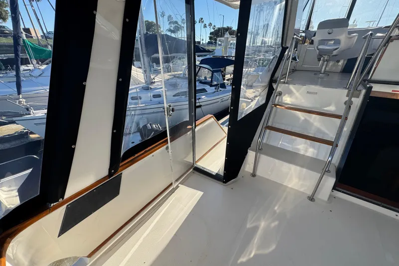 Slide: The Image of 1990 Sea Ray 380 Aft Cabin interior with marina view, featuring stairs and seating area. - 58