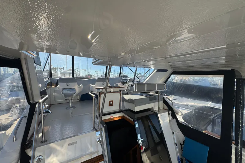 Slide: The Image of 1990 Sea Ray 380 Aft Cabin interior with helm, seating, and marina view. - 59