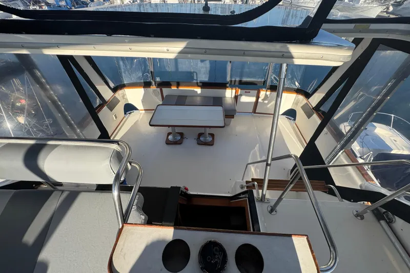 Slide: The Image of 1990 Sea Ray 380 Aft Cabin yacht interior with seating and table, enclosed by clear panels. - 64