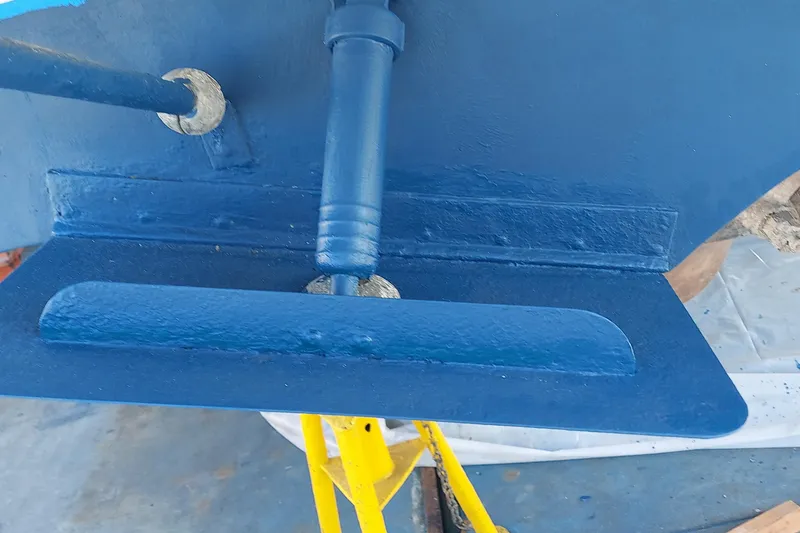 Slide: The Image of Close-up of a 1990 Sea Ray 380 Aft Cabin boat's blue-painted rudder and propeller shaft. - 77