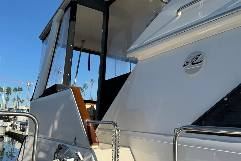 Slide: The Image of 1990 Sea Ray 380 Aft Cabin yacht docked, showcasing sleek design and logo. - 9