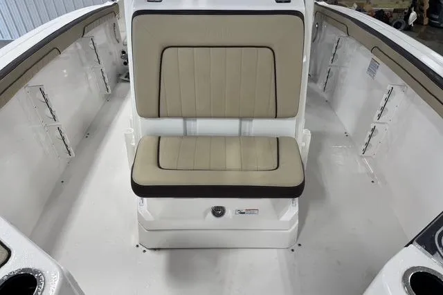 Slide: The Image of 2021 Yamaha Boats 255 FSH Sport E interior with beige seating and white deck. - 12