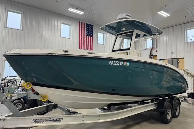 Slide: The Image of 2021 Yamaha Boats 255 FSH Sport E on trailer in indoor showroom. - 2