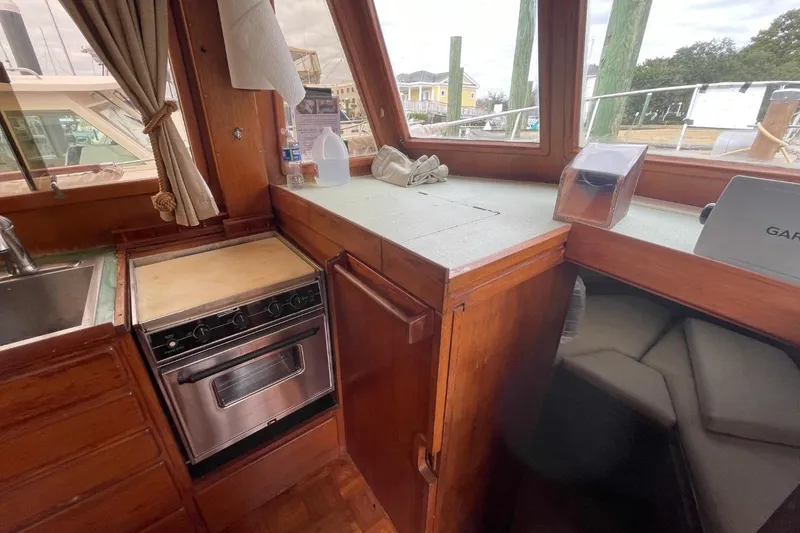 Slide: The Image of 1991 Marine Trader 34 Double Cabin interior with stove and sink in wooden cabinetry. - 17