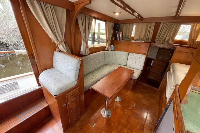 Slide: The Image of Interior of 1991 Marine Trader 34 Double Cabin with wood finish and cozy seating area. - 20