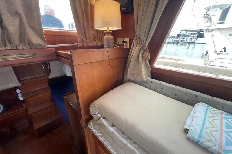 Slide: The Image of Cozy interior of 1991 Marine Trader 34 Double Cabin with wooden furnishings and dockside view. - 26